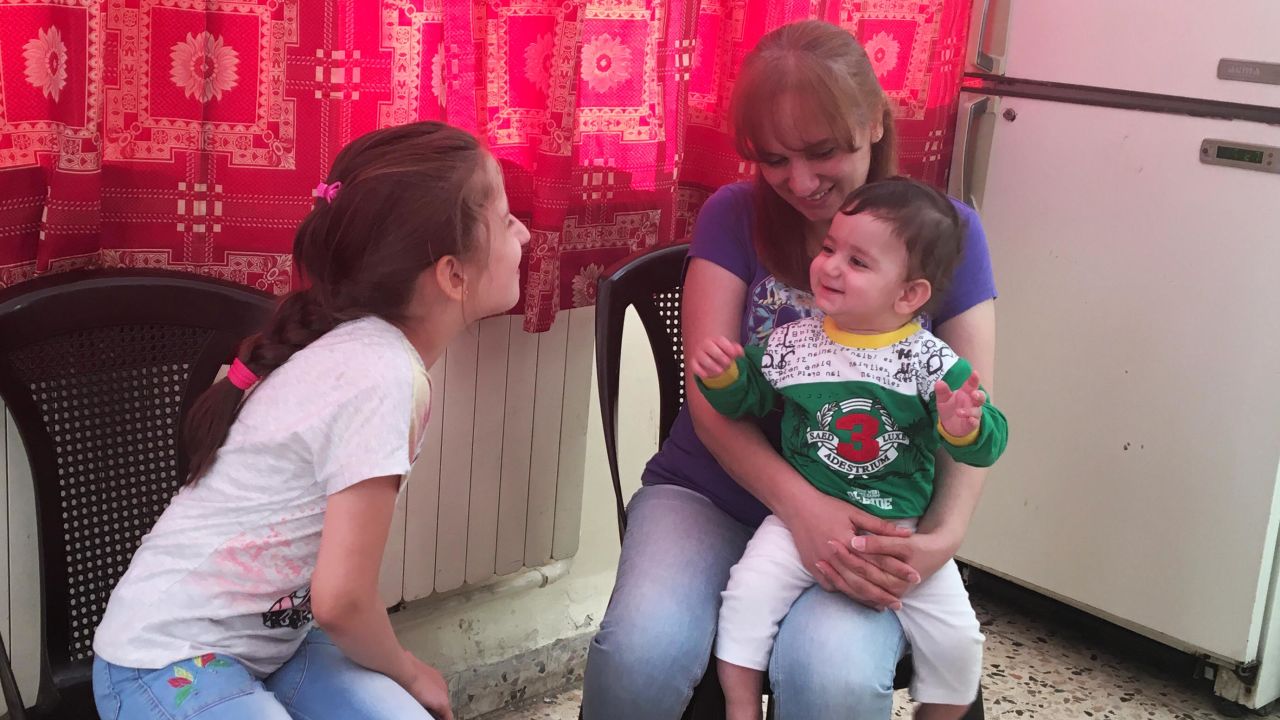 Anne plays with Rita, now nine, and her 10-month-old son Joseph, at the church in Amman, Jordan.
