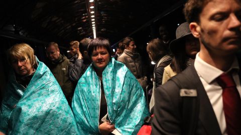 Passengers wear emergency blankets to keep warm outside the terminal.