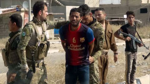 Kurdish security forces detain a suspected ISIS member on the outskirts of Kirkuk Saturday.