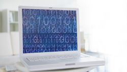 Laptop computer with binary code on screen.