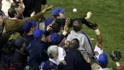 ** FILE ** In this Oct. 14, 2003 file photo, Chicago Cubs left fielder Moises Alou's arm is seen reaching into the stands, at right, unsuccessfully for a foul ball along with a fan identified as Steve Bartman, left, wearing headphones, glasses and Cubs hat, during the eighth inning against the Florida Marlins in Game 6 of the National League Championship Seriesin Chicago. (AP Photo/Morry Gash, File)