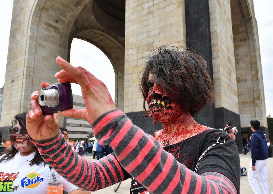 People take part in the annual "Zombie Walk" at the Revolution Square in Mexico City on October 22, 2016.