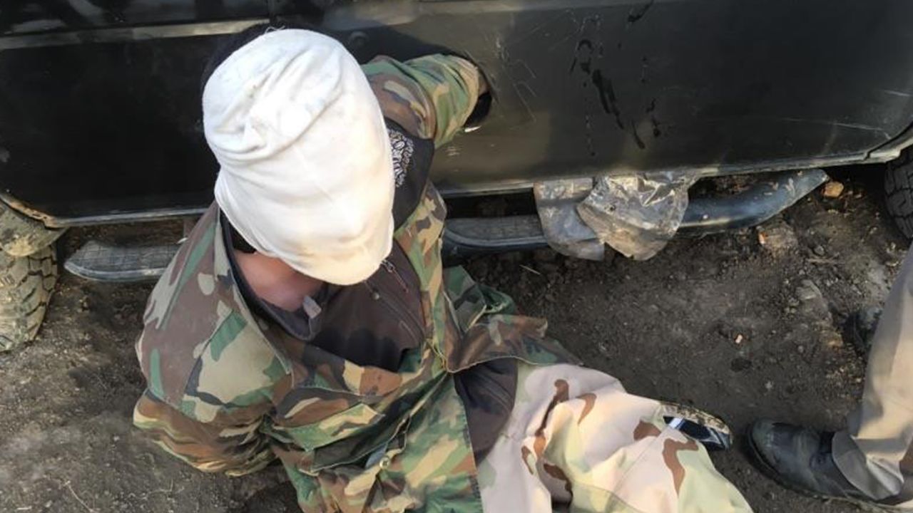 A protester attaches himself with a makeshift cast to a car.
