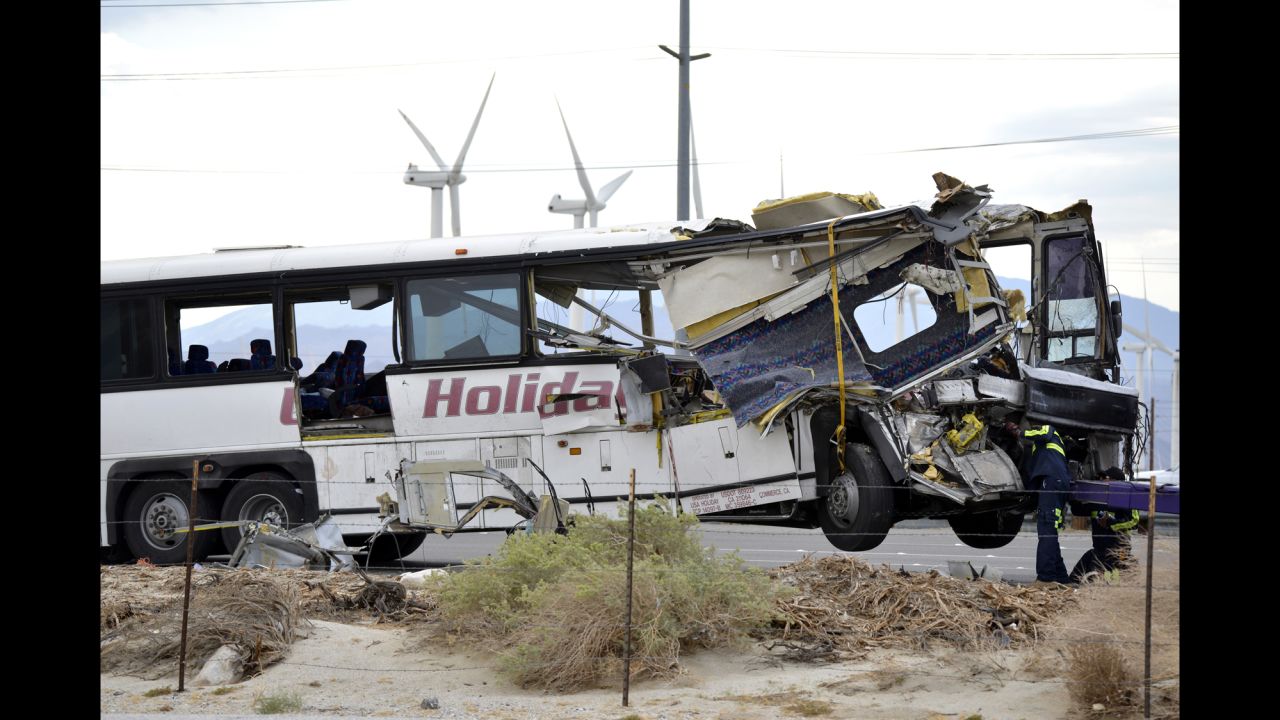 Workers prepare to haul away the mangled tour bus.