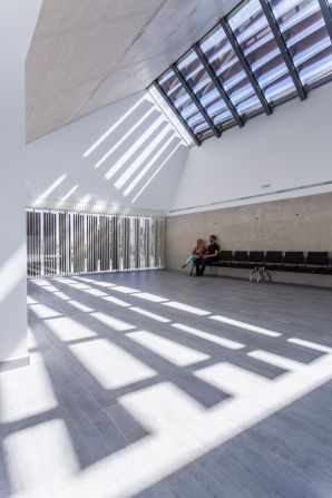 The concrete building features windows that cast shadows across the room, which move as the day goes on to symbolize the passage of time. <br />
