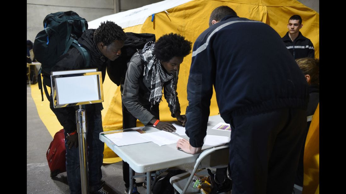 Migrants register with French authorities on October 24 before boarding buses that will transport them to shelters across France.