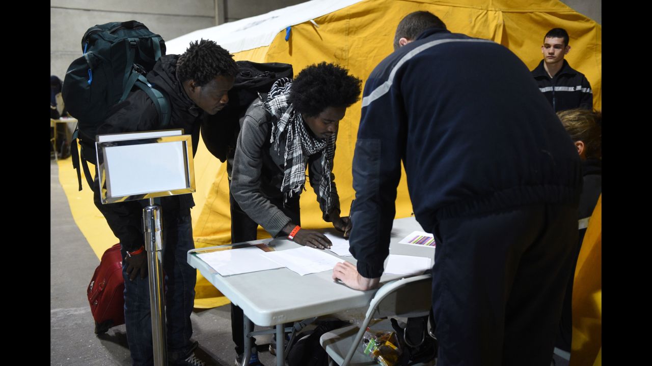 Migrants register with French authorities on October 24 before boarding buses that will transport them to shelters across France.