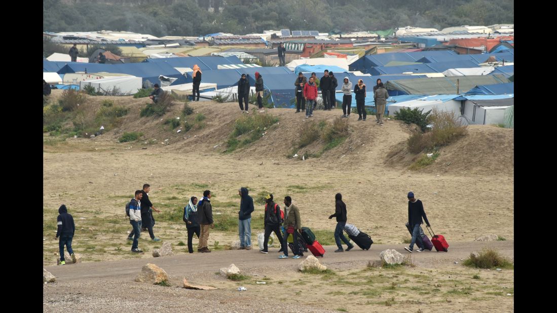 Migrants leave their makeshift homes on October 24.