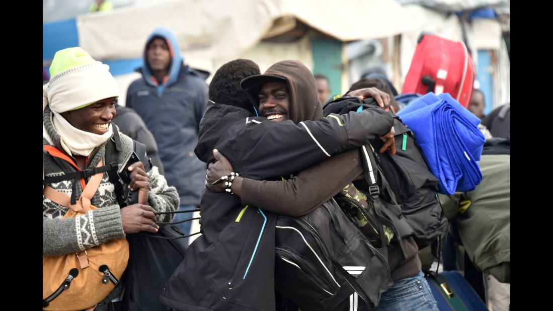 Residents of the camp hug before departing the "Jungle" on October 24.