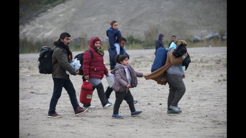 Men, women and children leave the camp during the first day of the planned eviction on October 24.  
