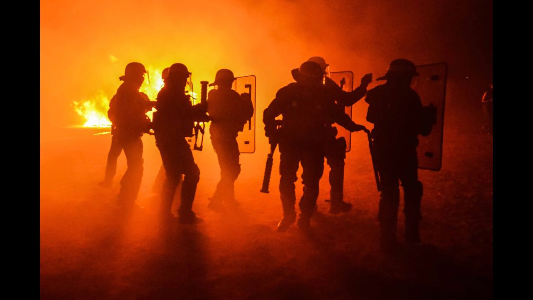 Riot police stand off with some of the camp's residents the night before the eviction was set to take place.