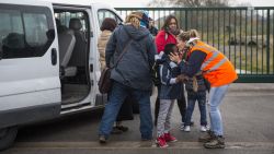 CALAIS, FRANCE - OCTOBER 24: Care workers bring child migrants to a reception point outside the Jungle migrant camp before boarding buses to refugee centres around France on October 24, 2016 in Calais, France. French authorities have begun to clear the estimated 7000 people from the Jungle migrant and refugee camp ahead of its demolition. (Photo by Jack Taylor/Getty Images)