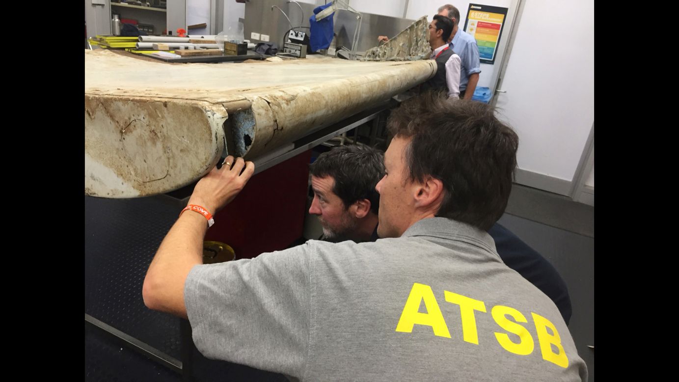 Staff members with the Australian Transport Safety Bureau examine a piece of aircraft debris at their laboratory in Canberra, Australia, on July 20. The flap was found in June by residents on Pemba Island off the coast of Tanzania, and officials had said it was highly likely to have come from Flight 370. Experts at the Australian Transport Safety Bureau, which is heading up the search for the plane, confirmed that the part was indeed from the missing aircraft.
