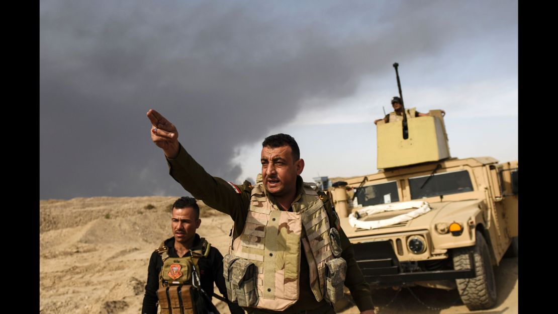 A member of Iraqi forces gestures towards the frontline on October 18, near the town of Qayyara, during an operation to recapture the city of Mosul from ISIS.