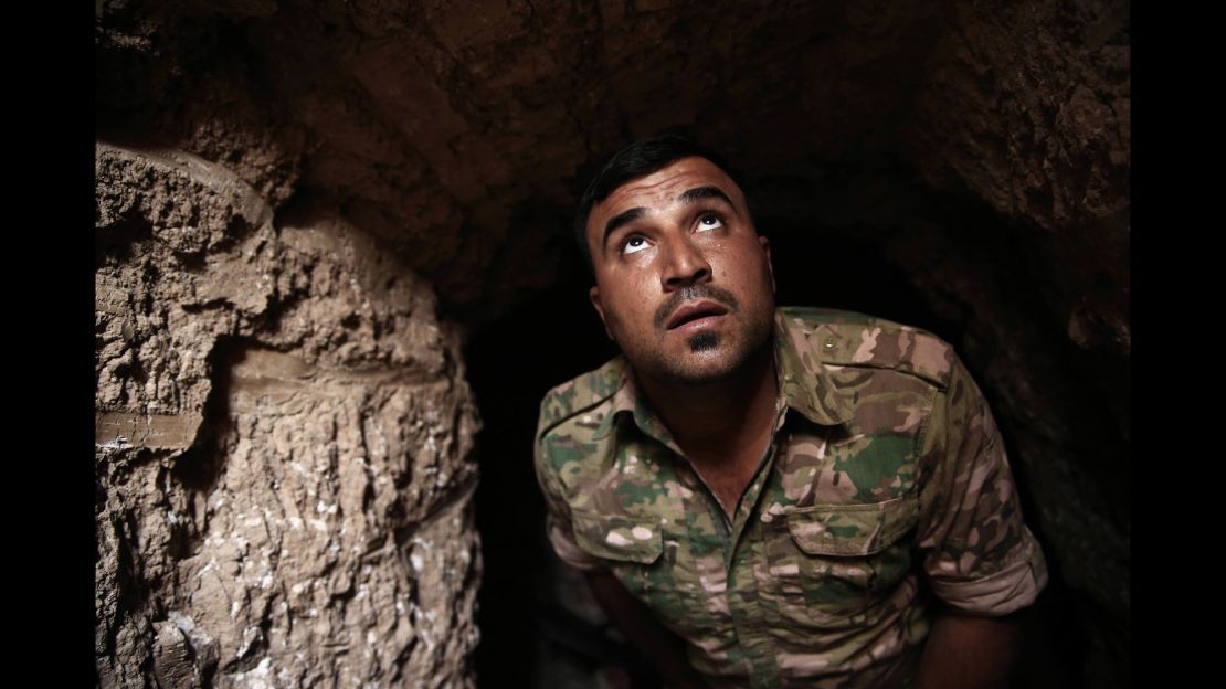 A Peshmerga fighter peers up from an underground tunnel in the liberated town of Badana on October 18. ISIS built tunnels below residential streets to escape from airstrikes.