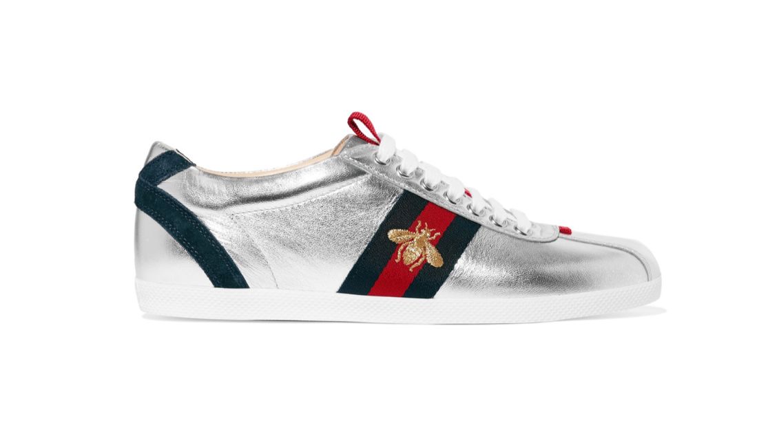 Gucci became the first luxury designer brand to produce sneakers in 1984. It's <a href="https://www.mrporter.com/en-gb/product/704456?cm_mmc=ProductSearchPLA-_-GB-_-Shoes-_-Sneakers-Google&ignoreRedirect=true&ppv=2&cm_mmc=GoogleUK--c-_-MRP_UK_EN_PLA-_-UK%20-%20GS%20-%20Price%20Bands---_-__pla-104396119772&mkwid=sVWlc3CyT|112601668629|||c&DD=&gclid=COjdvcDK9c8CFTQo0wod3GsGZQ" target="_blank" target="_blank">first classic tennis shoe</a>, made of Italian white leather with the brand's signature red and green stripes, led many ateliers to follow suit, eventually sparking more daring iterations such as this silver sneaker with gold embroidered bee.  