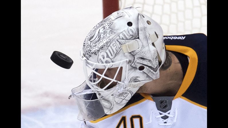 The puck flies near the face of Buffalo goalie Robin Lehner as he plays an NHL game in Vancouver, British Columbia, on Thursday, October 20.