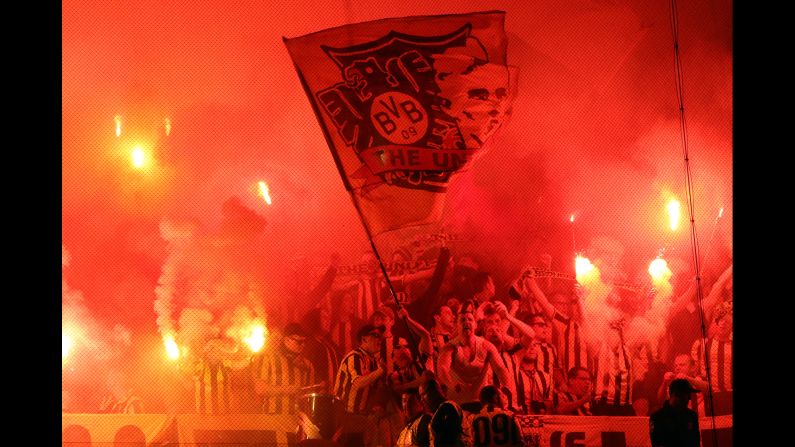 Supporters of the German soccer club Borussia Dortmund light flares during a Champions League match in Lisbon, Portugal, on Tuesday, October 18.