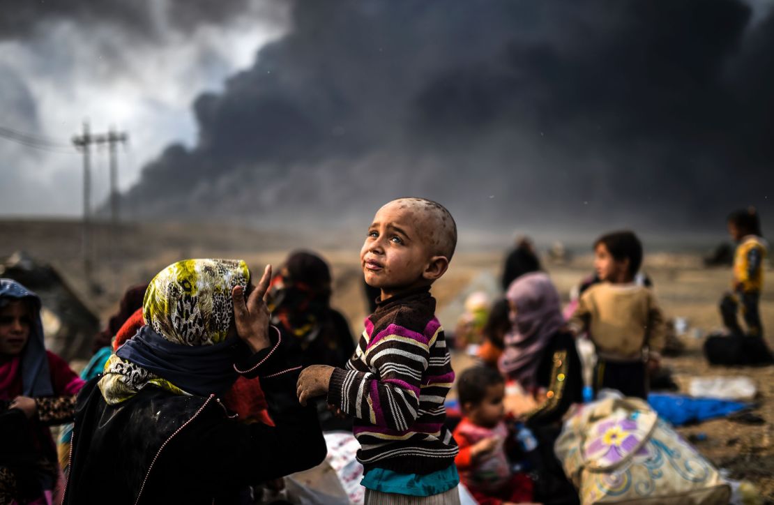 Displaced families gather in an area near Qayyara on October 24.