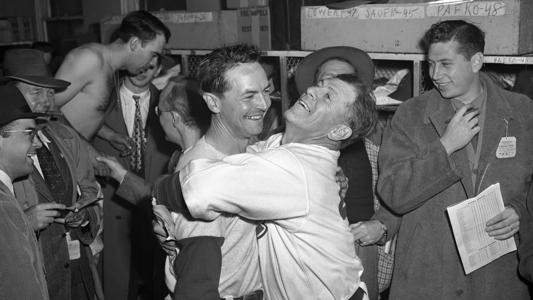 Cubs manager Charlie Grimm, center right, hugs third baseman Stan Hack in the clubhouse after he hit a game-winning double in extra innings to tie the series at three games apiece.