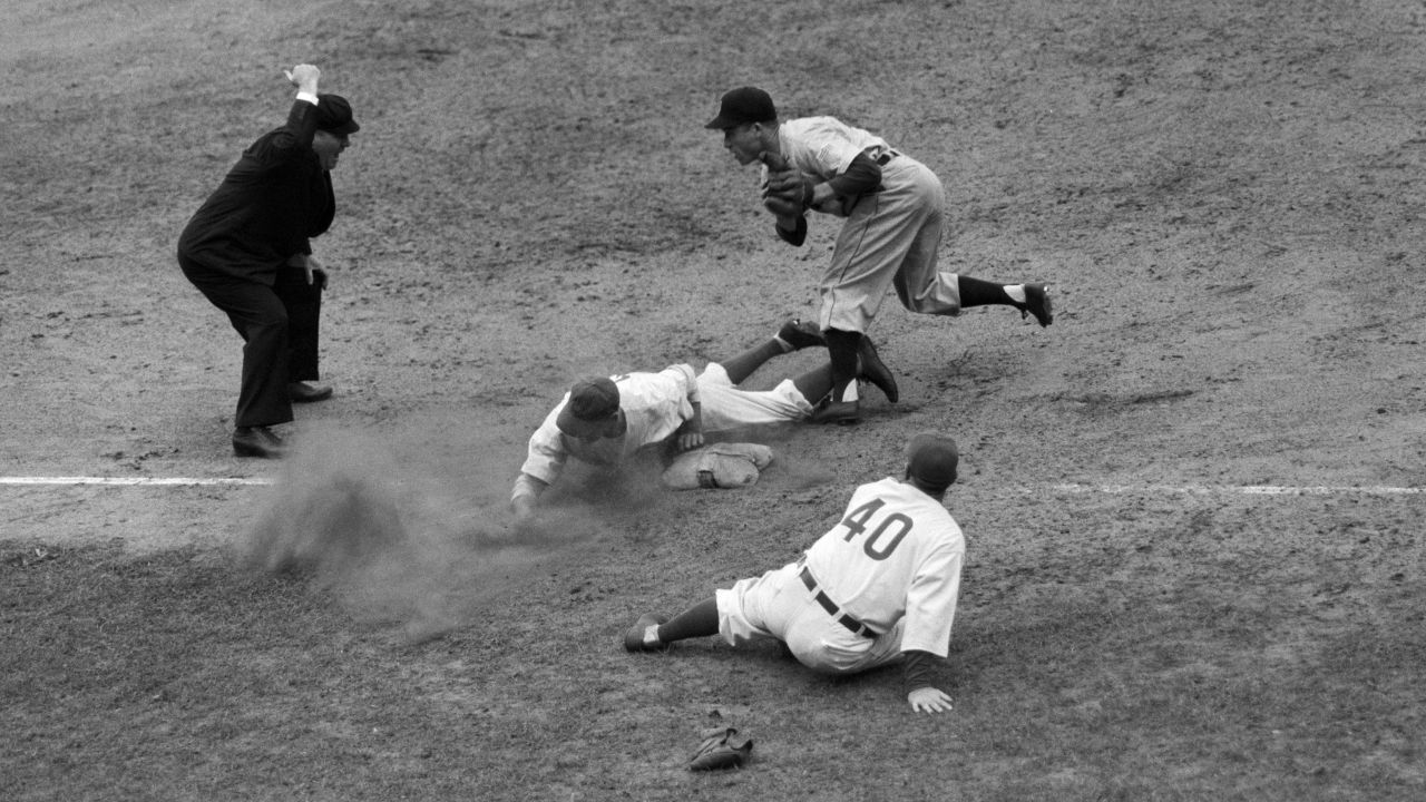 Roy Hughes of the Cubs slides head-first into third base during game six.<br />