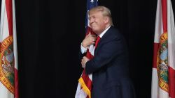 Donald Trump hugs the American flag as he arrives for a campaign rally at the MidFlorida Credit Union Amphitheatre on October 24, 2016 in Tampa, Florida. 
