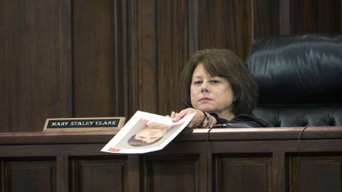Cobb County Superior Court Judge Mary Staley Clark holds a booking mug shot of Justin Ross Harris.