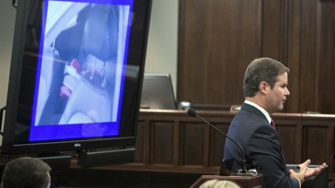 Cobb County Senior Assistant District Attorney Chuck Boring shows the jury a photo of a child's car seat in the back seat of Harris's car.