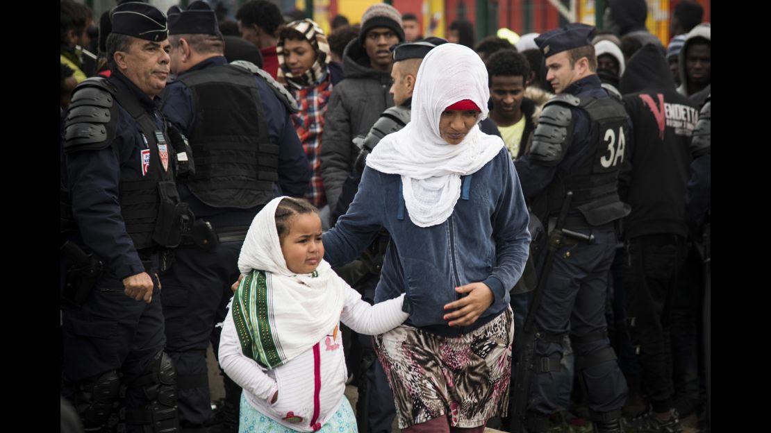 Refugees get ready to leave Calais as demolition begins at the Jungle migrant camp Tuesday.