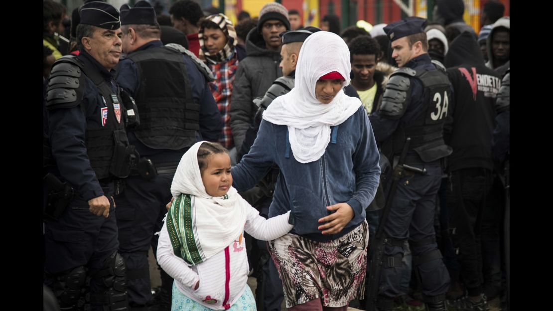 Refugees get ready to leave Calais as demolition begins at the Jungle migrant camp Tuesday. 