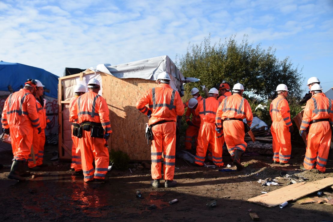 Workers begin the demolition of the Calais "Jungle" camp on Tuesday.