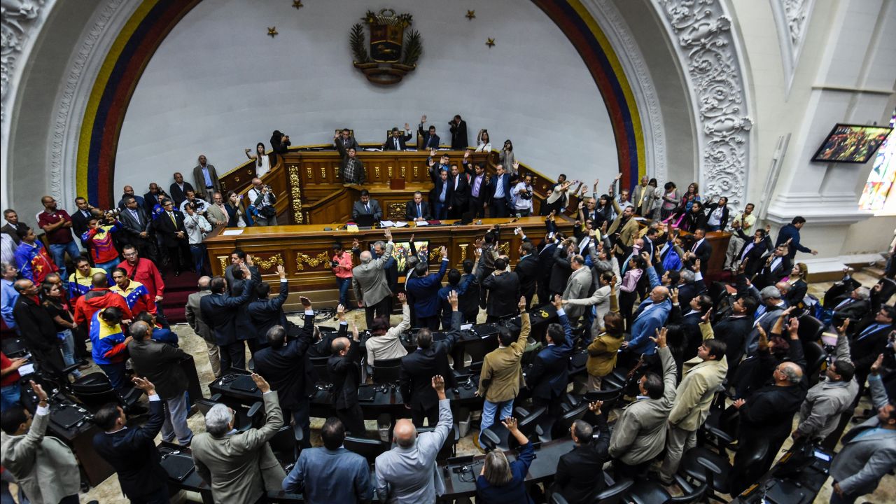 Opposition deputies raise their hands while voting to open a political trial against President Nicolas Maduro. A majority of lawmakers voted in favor of a motion to launch a "political and criminal trial" after his government blocked their drive for a referendum on removing him.