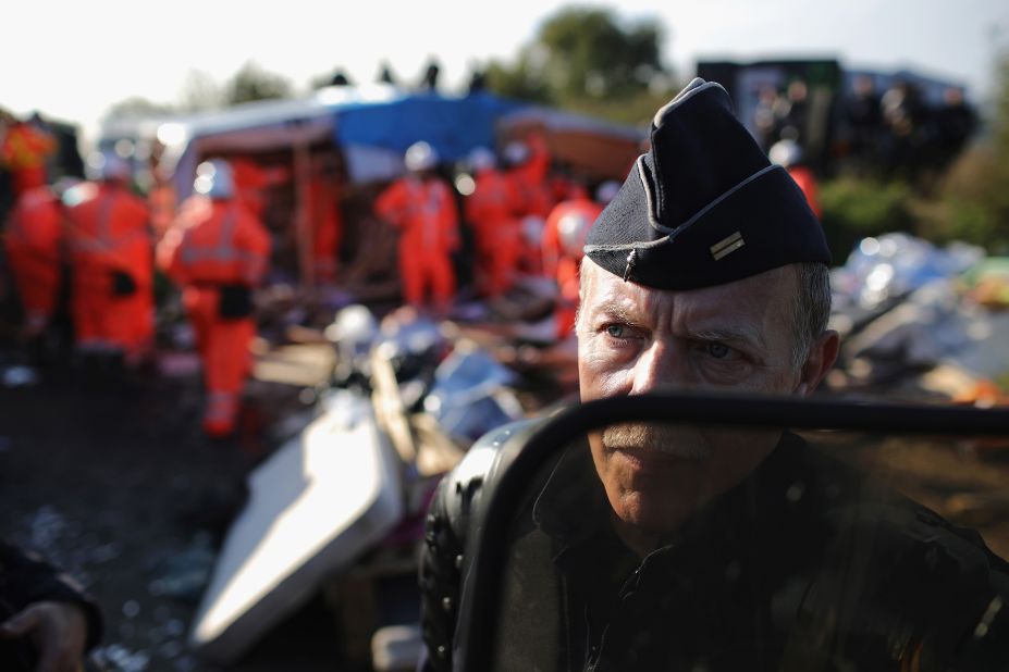 A police officer guards demolition crews as they work to dismantle the site on October 25.