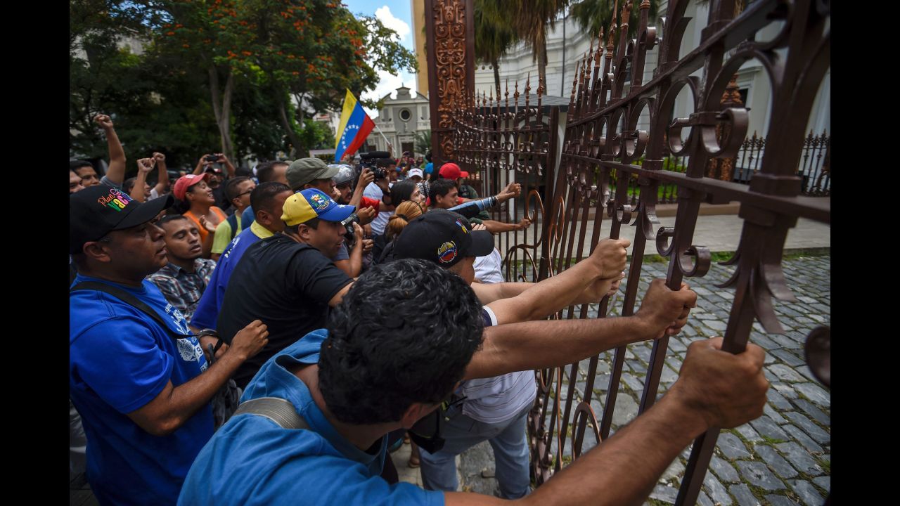 Supporters of Maduro break the gate and force their way to the National Assembly during an extraordinary session called by opposition leaders. Each side accuses the other of staging a coup in the country, which is in the midst of economic and political strife.
