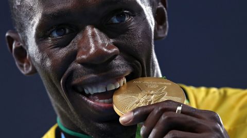 Bolt bites his gold medal after the 4x100 meter relay at the Rio 2016 Olympics.