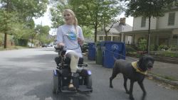 Flesh-eating bacteria survivor Aimee Copeland rides her wheelchair down an Atlanta street with her service dog, Belle, on April 11, 2016.