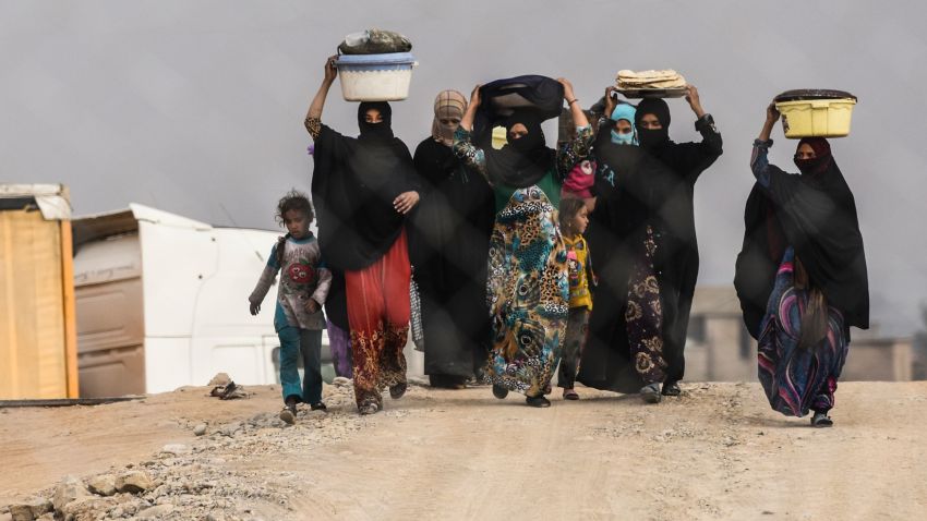 Iraqi families, who were displaced by the ongoing operation by Iraqi forces against jihadistds of the Islamic State group to retake the city of Mosul, walk at a camp for displaced people near Qayyarah on October 24, 2016.