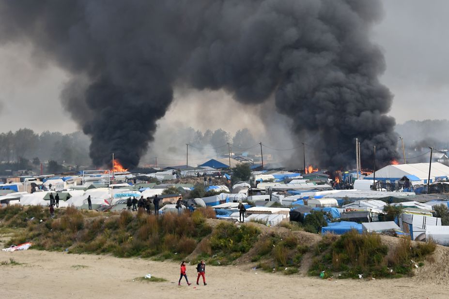 Smoke rises from multiple fires blazing in the camp on Wednesday, October 26, as French authorities work to demolish the settlement and evacuate its residents to reception centers around France.