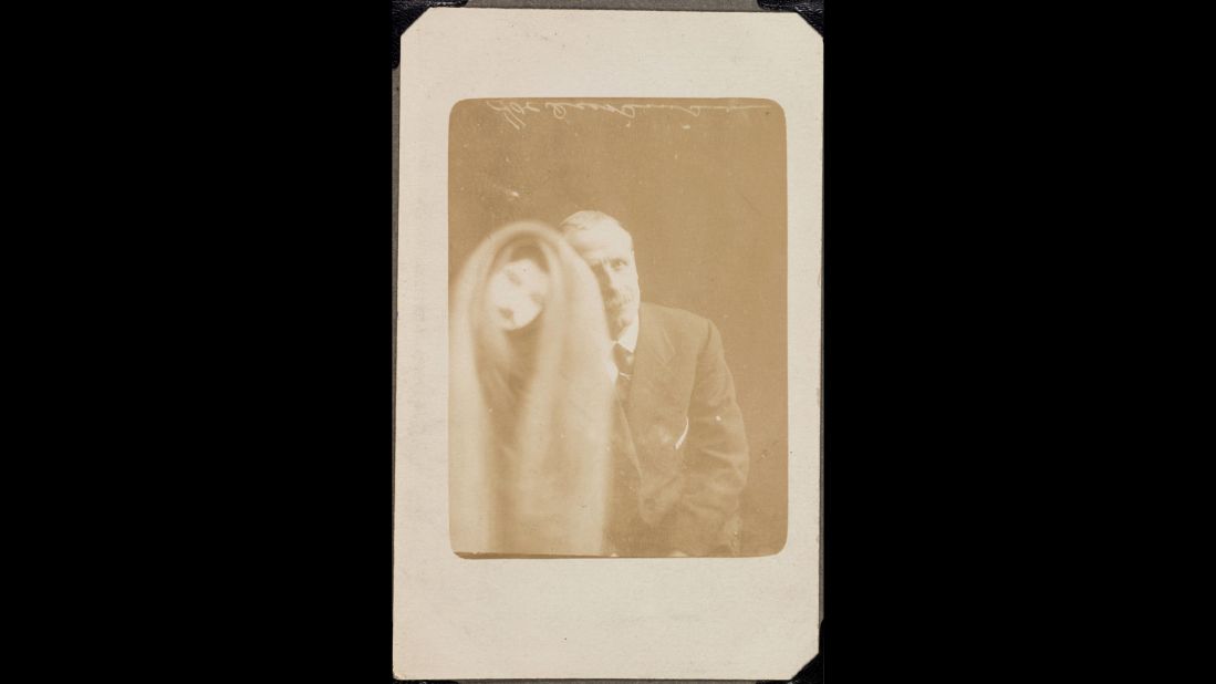 A cloaked face appears over a man's photograph. The man apparently identified it as an ex-colleague who had died 32 years earlier. Spirit photography was popular in the late 19th century and early 20th century. Many people were desperate to connect with lost loved ones, especially after World War I.