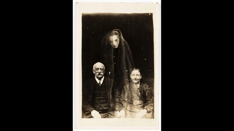 A young woman's face, draped in a cloak, seems to float above an older couple.