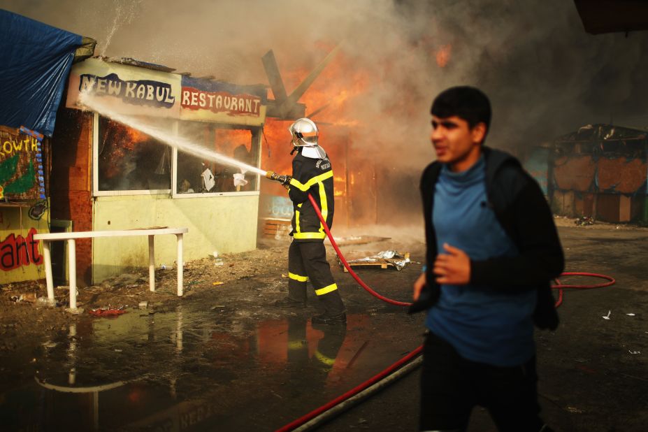 A French fireman attempts to extinguish a blaze in the Calais Jungle on October 26. 