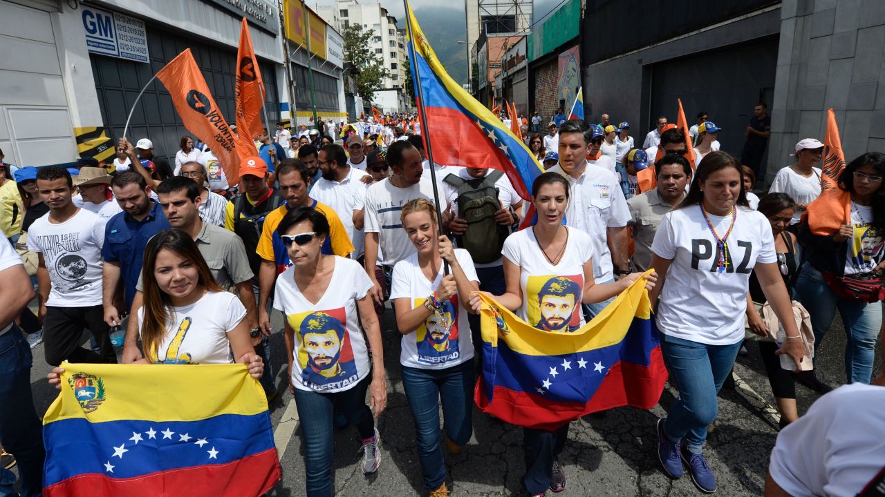 Lilian Tintori, wife of prominent jailed opposition leader Leopoldo Lopez, holds a Venezuelan flags as she marches.