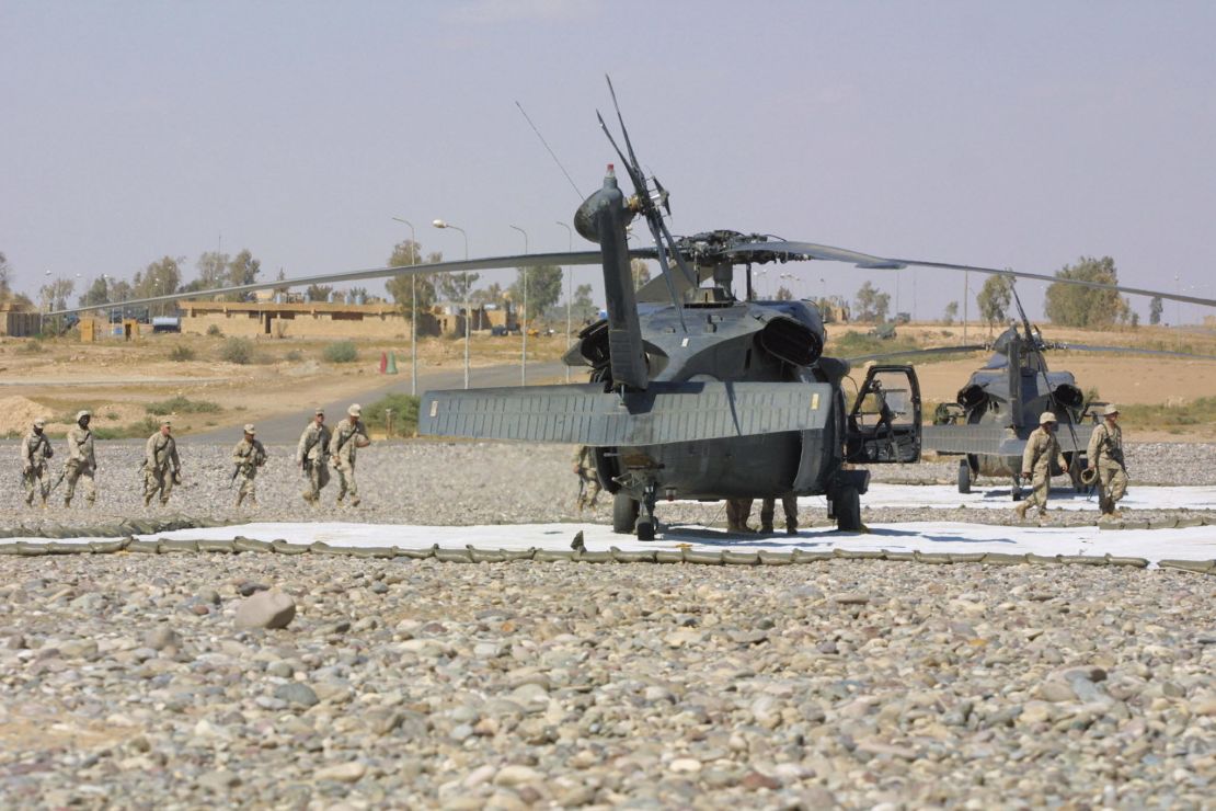 US troops from the 101st Airborne Division walk past Blackhawk helicopters Qayyara airbase