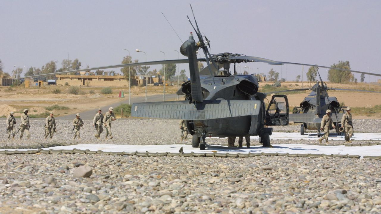 US troops from the 101st Airborne Division walk past Blackhawk helicopters Qayyara airbase