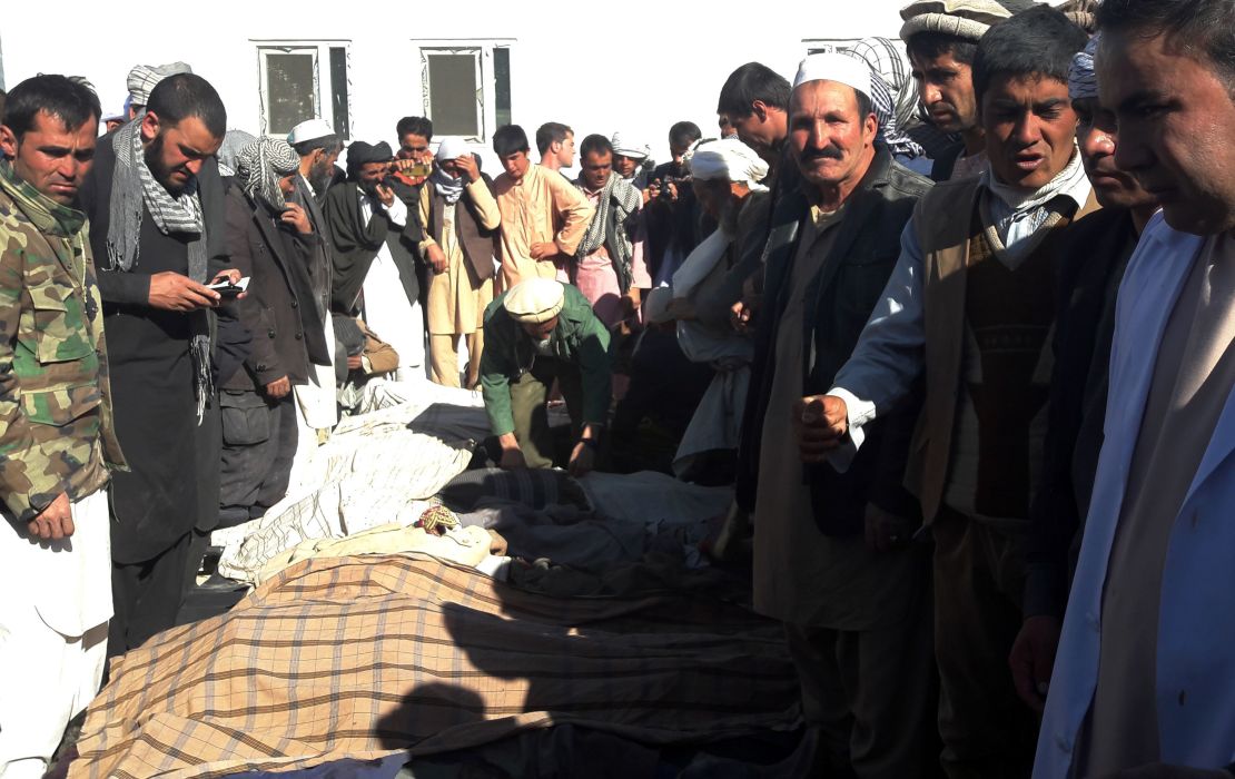Afghan men gather around the bodies of civilians killed by ISIS militants on October 26.