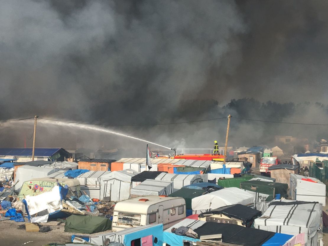 Firefighters struggle to control the dozens of fires tearing through the camp.