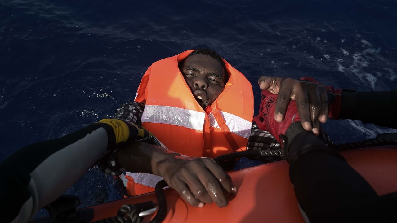 TOPSHOT - A migrant is rescued by members of Proactiva Open Arms NGO in the Mediterranean Sea, some 12 nautical miles north of Libya, on October 4, 2016.
At least 1,800 migrants were rescued off the Libyan coast, the Italian coastguard announced, adding that similar operations were underway around 15 other overloaded vessels. / AFP / ARIS MESSINIS (Photo credit should read ARIS MESSINIS/AFP/Getty Images)