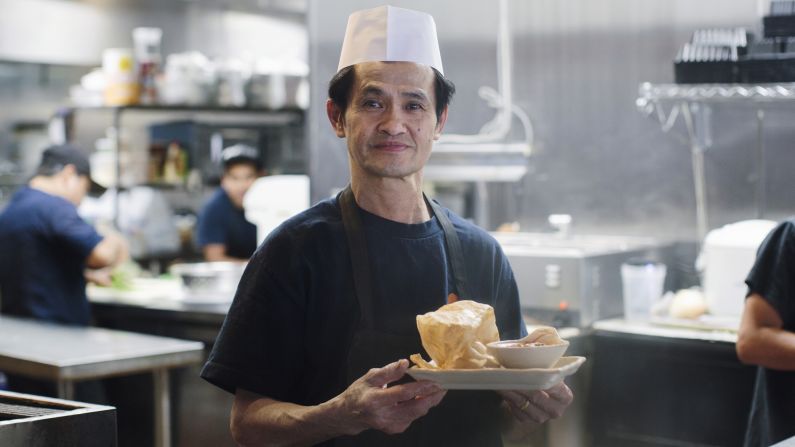 Ming Ng, a cook at Mamak Malaysian restaurant in Houston, holds the roti canai dish. It's "crispy on the outside, fluffy on the inside," the menu says.