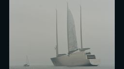 TOPSHOT - A sailboat (L) passes the world's largest superyacht called 'A' during it's first sailing test in Strande, nearby Kiel, northern Germany, on a foggy October 16, 2016.
The luxury yacht was built at a shipbuilding yard near Hamburg. / AFP / dpa / Axel Heimken / Germany OUT        (Photo credit should read AXEL HEIMKEN/AFP/Getty Images)