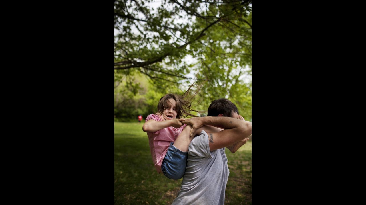 One of the twins slips off her father's shoulders as they play in Athens, Ohio, in 2009. Eich's college assignment was to document a community through photos. He found one with tenacity, intimacy and love, even in the depths of loss and poverty.  